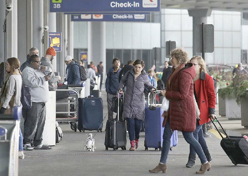 Travelers head to their gates Sunday at O’Hare International Airport in Chicago.
