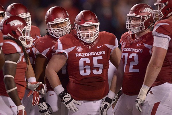 Arkansas guard Sebastian Tretola (73), center Mitch Smothers (65) and guard Frank Ragnow (72) huddle during a timeout in the second quarter of a game against Mississippi State on Saturday, Nov. 21, 2015, at Razorback Stadium in Fayetteville. 