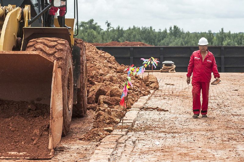 A worker walks alongside a bulldozer at a ShanDong ZhongJiao Navigation Engineering Co. construction site near Boke, Guinea, in September. China’s trade with Africa topped $200 billion last year.