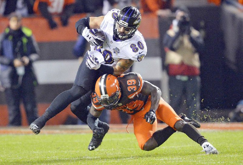 Baltimore Ravens tight end Crockett Gillmore (80) is hit by Cleveland Browns free safety Tashaun Gipson (39) after Gillmore ran for a fi rst down during the second half of Monday’s game in Cleveland. The Ravens made up for a third-quarter interception return for touchdown when safety Will Hill blocked a 51-yard field goal attemptand returned it 64 yards for the game-winning touchdown.
