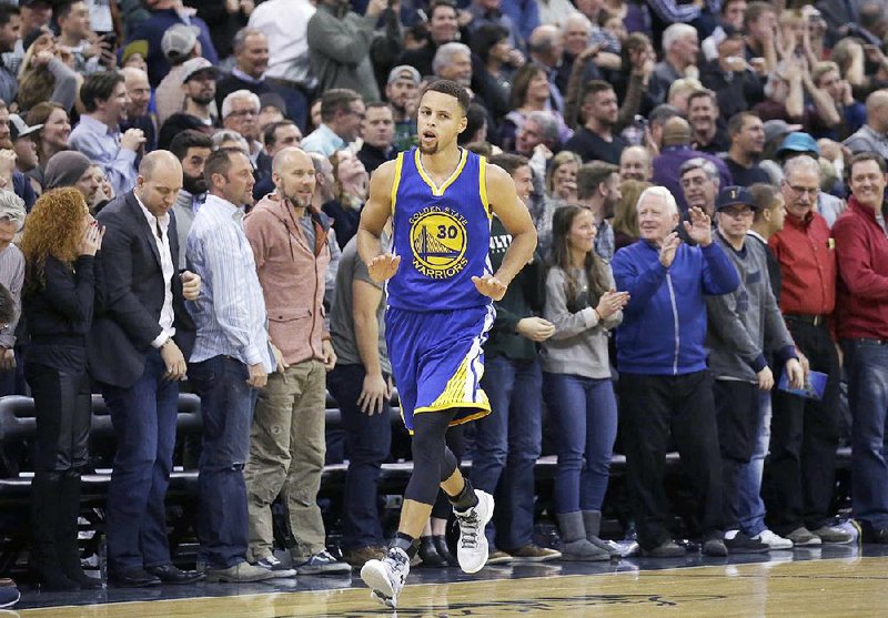 Golden State Warriors guard Stephen Curry (30) runs back to his bench after making a 3-pointer against the Utah Jazz in the second half during an NBA basketball game Monday, Nov. 30, 2015, in Salt Lake City.  