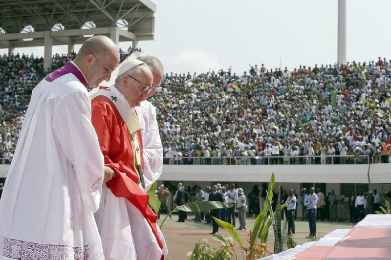 Pope Francis is helped up the altar steps during a Mass he celebrated Monday at Barthelemy Boganda Stadium in Bangui, Central African Republic.