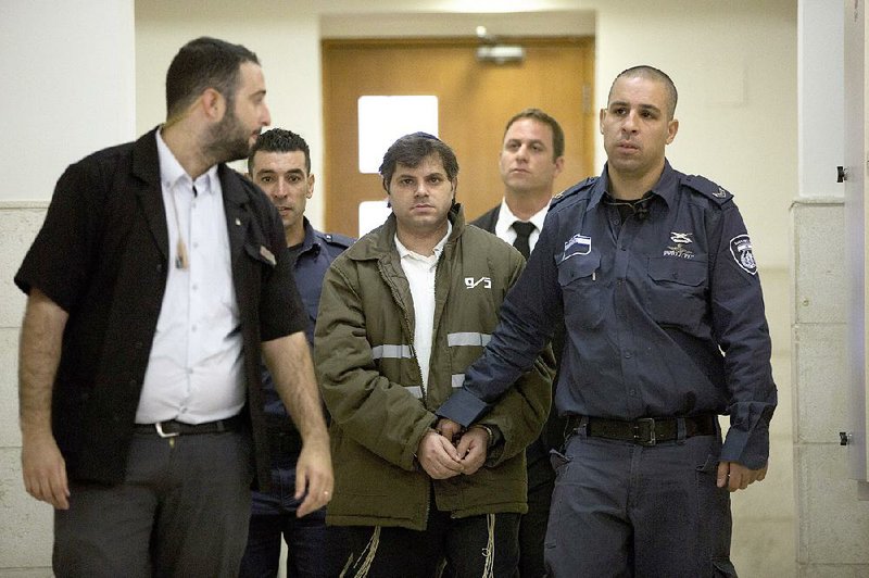 Yosef Haim Ben David (center), a suspect in the killing of a Palestinian boy last year, arrives Monday at Jerusalem District Court.