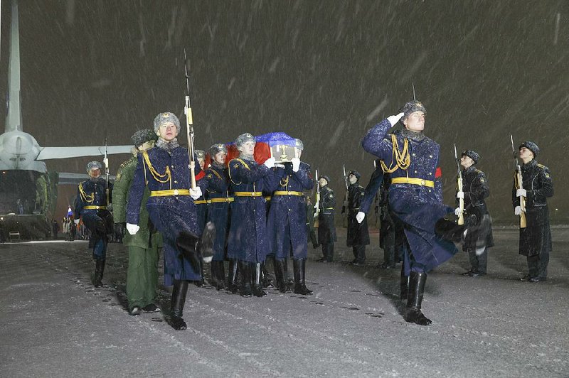 A Russian honor guard escorts a coffin with the body of Russian Lt. Col. Oleg Peshkov during a mourning ceremony Monday at Chkalovsky military airport outside Moscow. Peshkov was co-pilot of a jet that was shot down by a Turkish plane last week.