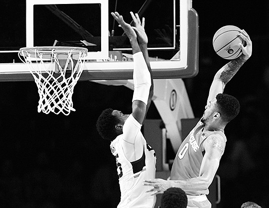 The Associated Press FAST ORANGE: Syracuse forward Michael Gbinije (0) takes the ball to the basket as Connecticut center Amida Brimah defends during the semifinals of the Battle 4 Atlantis Thursday in Paradise Island, Bahamas. There are five newcomers in The Associated Press Top 25 this week, with Syracuse being the highest at 14th.