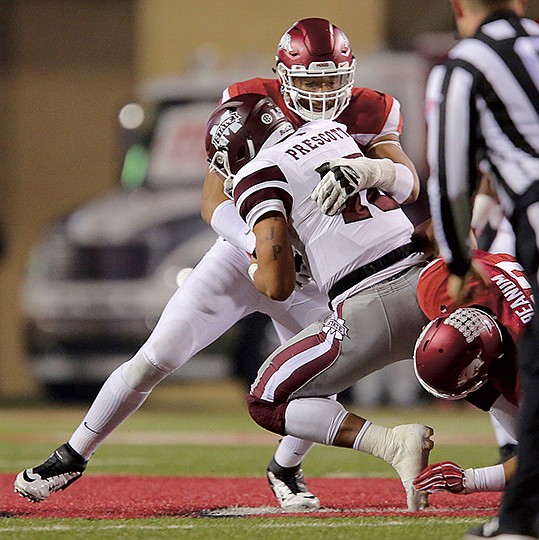 Arkansas Democrat-Gazette/Stephen B. Thornton WISE PICK: Arkansas defensive end Deatrich Wise sacks Mississippi State quarterback Dak Prescott (15) during the second quarter Nov. 21 in Fayetteville. Wise was named the Southeastern Conference co-defensive lineman of the week Monday following his Friday performance against Missouri, two sacks, a forced fumble and two hurries, and the Razorbacks' offensive line was named a finalist for the new Joe Moore Award for the nation';s top line.