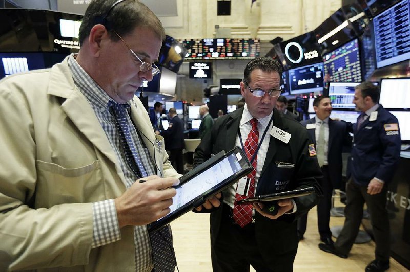 Traders Jonathan Niles (left) and Edward Curran work Tuesday on the floor of the New York Stock Exchange. 