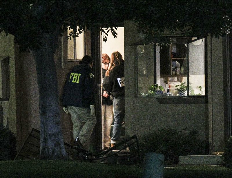 FBI agents search a home Thursday in Redlands, Calif., where Syed Rizwan Farook and Tashfeen Malik apparently lived. Investigators found a cache of ammunition, as well as a dozen pipe bombs.