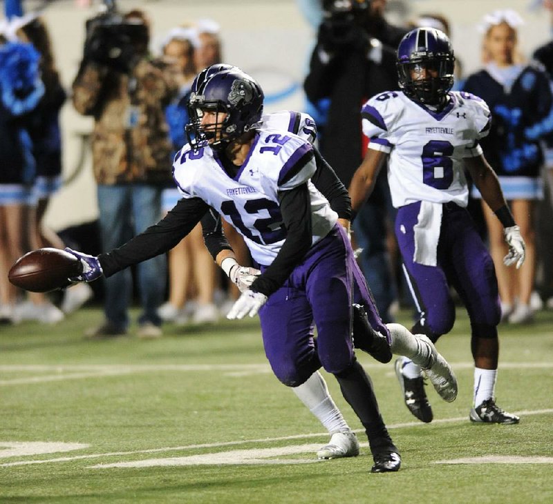 Fayetteville safety Joey Savin celebrates after making an interception during the Bulldogs’ victory over Springdale Har-Ber in the Class 7A championship game Saturday night at War Memorial Stadium in Little Rock. Savin finished with three interceptions, a record for a state championship game, and the Bulldogs won their fourth state title since 2007.