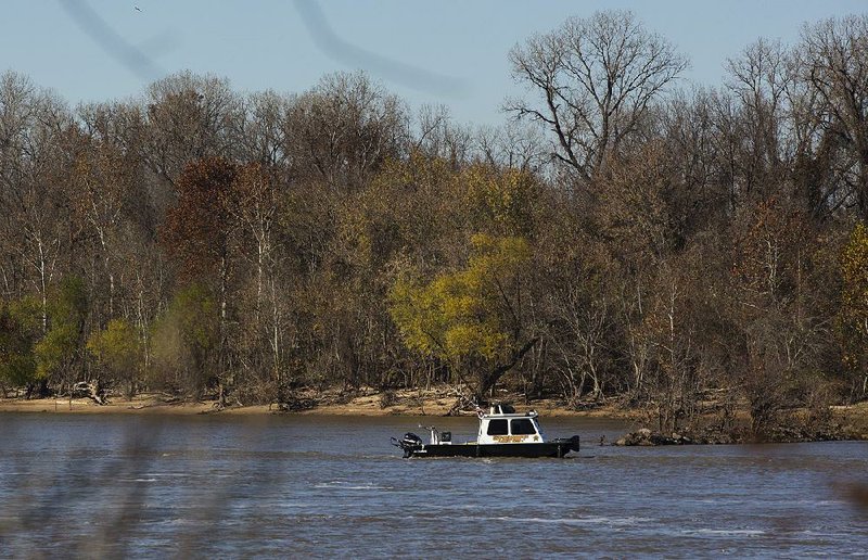 Authorities in a Pulaski County sheriff’s office boat search the Arkansas River between Little Rock and North Little Rock on Saturday, Dec. 5, 2015, after a human leg was found in the water. 