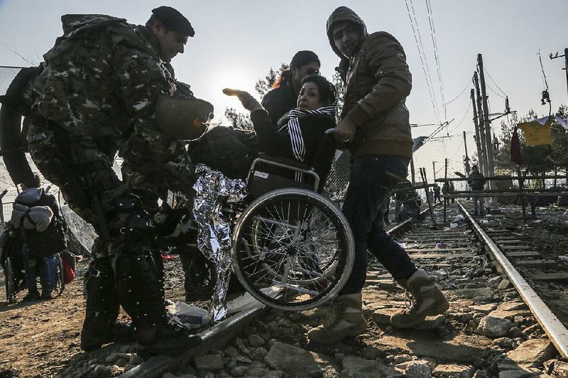 Macedonian border police move a migrant who crossed over from Greece on Saturday near the Macedonian town of Gevgelija. Macedonia is allowing entry only to people from Afghanistan, Iraq and Syria.
