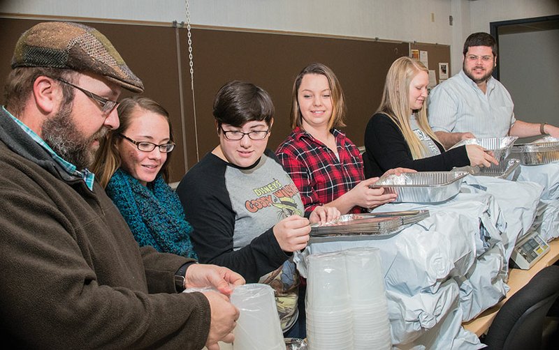 Sean Huss, from left, associate professor of sociology at Arkansas Tech University in Russellville, with students Lauren Palmer, Kendall Tubb, Kaylynn Newhard and Jenna Cahoon and assistant professor of sociology James Stobaugh, unpack pans that will be used to store food that is saved from the campus cafeteria. The students, part of the Because We Can organization on campus, won a $6,000 grant to start the food-recovery program. Huss and Stobaugh are co-advisers of the group.