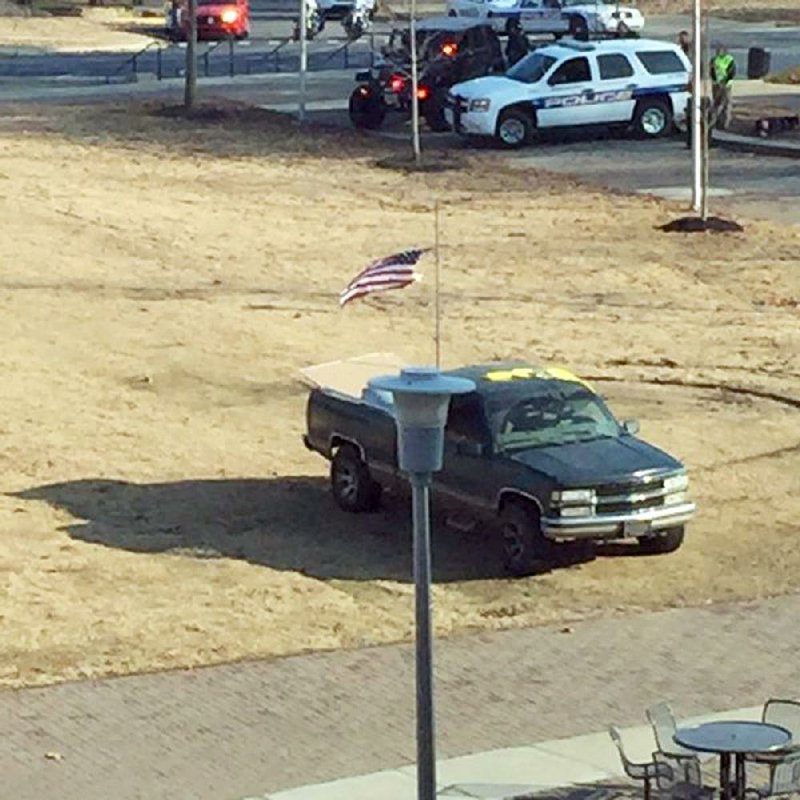 Officers surround a truck Thursday afternoon near Arkansas State University’s student union during a standoff with a gunman, identifi ed by police as Brad Bartelt of Jonesboro, who later surrendered.