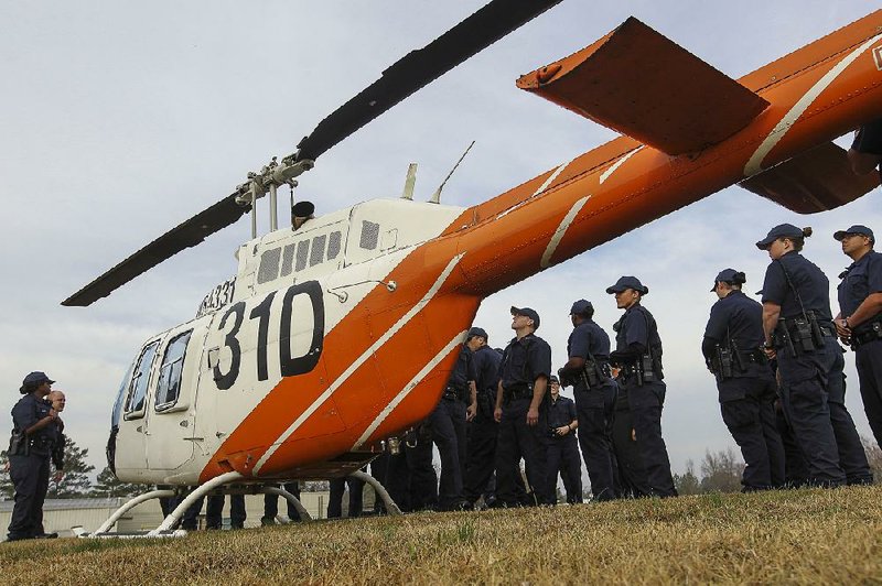 Members of the Little Rock Police Department recruit class look over the department’s new 2001 Bell Jet Ranger helicopter during an unveiling at the Police Training Division on Thursday morning. The department acquired the helicopter at no cost through a government surplus program.