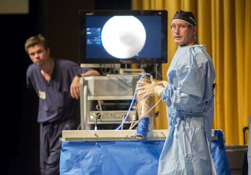 Dr. Chris Dougherty answers questions Thursday, after performing an ACL procedure on a cadaver leg at Bentonville’s Arend Arts Center.