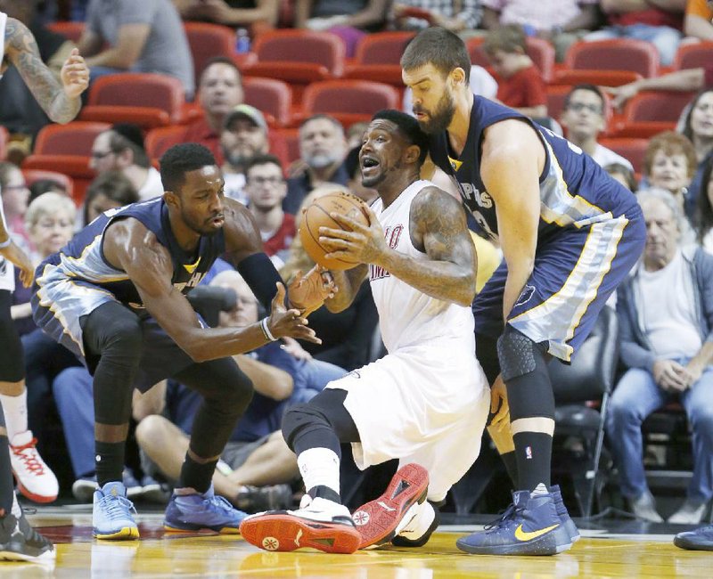 Miami forward Udonis Haslem (center) snatches a loose ball while Memphis defenders Jeff Green (left) and Marc Gasol close in during Sunday’s game. The Heat battled back from a seven-point, fourth-quarter deficit to beat the Grizzlies 100-97.
