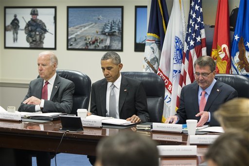 President Barack Obama looks at his notes as he sits with Vice President Joe Biden and Defense Secretary Ash Carter during a meeting with the National Security Council about the fight against the Islamic State group on Monday, Dec. 14, 2015, at the Pentagon. 