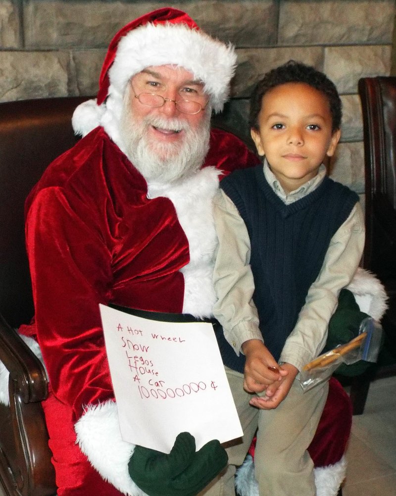 Photo by Randy Moll Robert Collins, 6, had his list ready for Santa when he visited with Mr. Claus at the Gentry Chamber of Commerce office on Saturday. Put in the decimal point and count the zeros for the dollar amount to go with a house and a car.