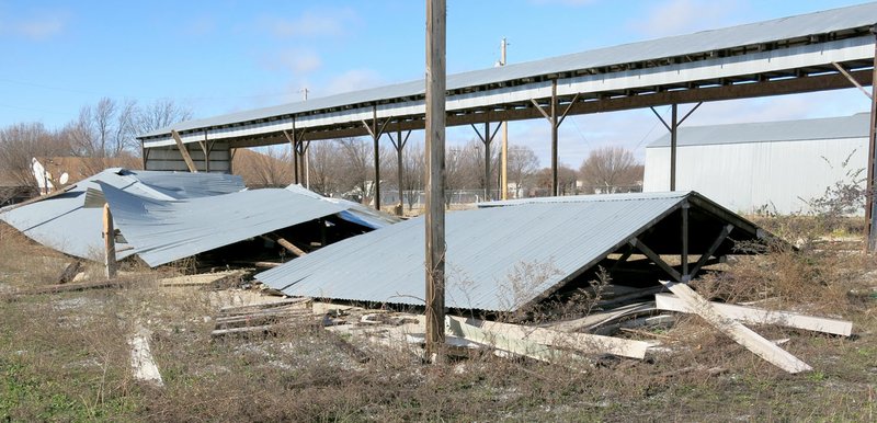 Photo by Susan Holland One of the long open sheds once used to store lumber at the former Westfield Home Center in Gravette was destroyed by high winds Sunday night. In the background an identical shed can be seen still standing. Police chief Andy Bower said no reports of wind damage were received at his department.