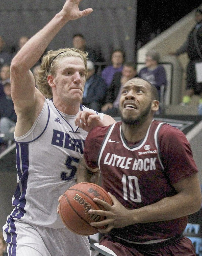 UALR’s Maurius Hill goes for the basket against Central Arkansas’ Jake Zuilhof in the the first half of the Trojans’ 77-54 victory Tuesday at the Farris Center in Conway.