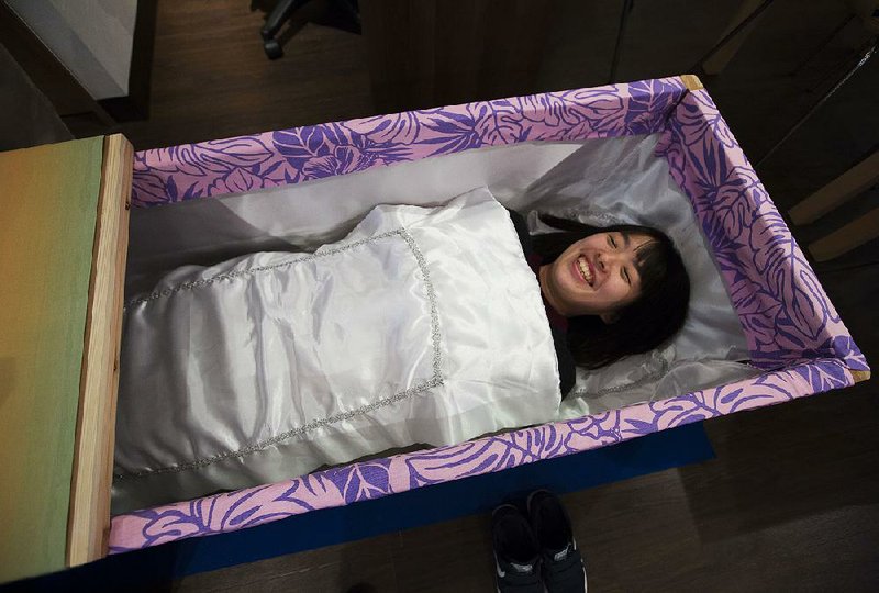 A participant lies in a coffin during a Coffin Experience event at the Blue Ocean Cafe in Tokyo in November. 