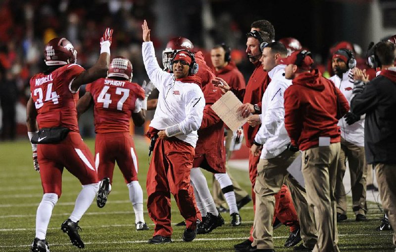 NWA Media/ANDY SHUPE - Arkansas assistant coach Michael Smith high-fives with players against LSU during the third quarter Saturday, Nov. 15, 2014, at Razorback Stadium in Fayetteville.