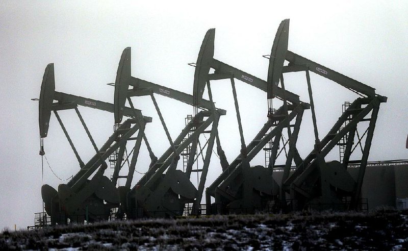 Pump jacks work in unison to pull oil from a field in Williston, N.D., in this fi le photo. Congress voted Friday to let energy companies export U.S. crude for the first time since an oil embargo forced Americans to ration gasoline 40 years ago.