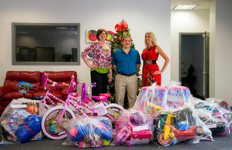 Lifeplus in Batesville was one of several business in Independence County to help with the 2015 United Way Angel Tree Program. From left are Amanda Tate, Rick Cesarski and Tracy Smith, showing some of the gifts that were collected by employees for distribution. 