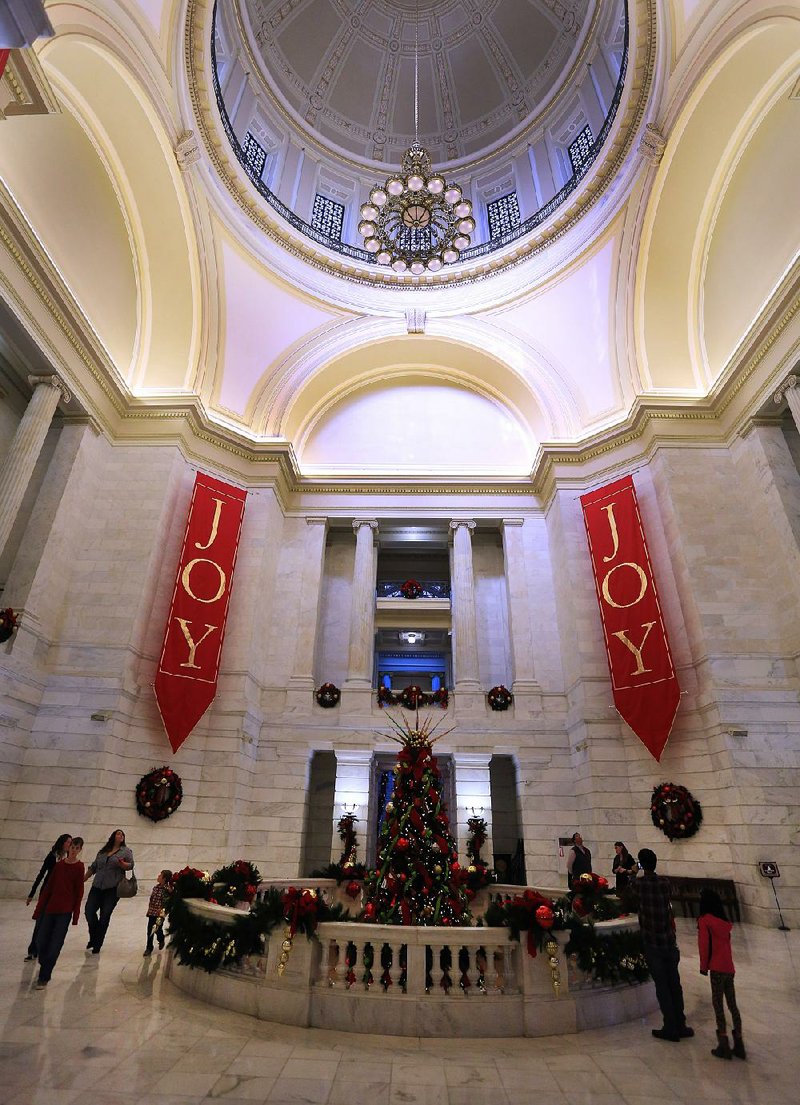 Visitors to the state Capitol admire Christmas decorations in the rotunda area Tuesday.