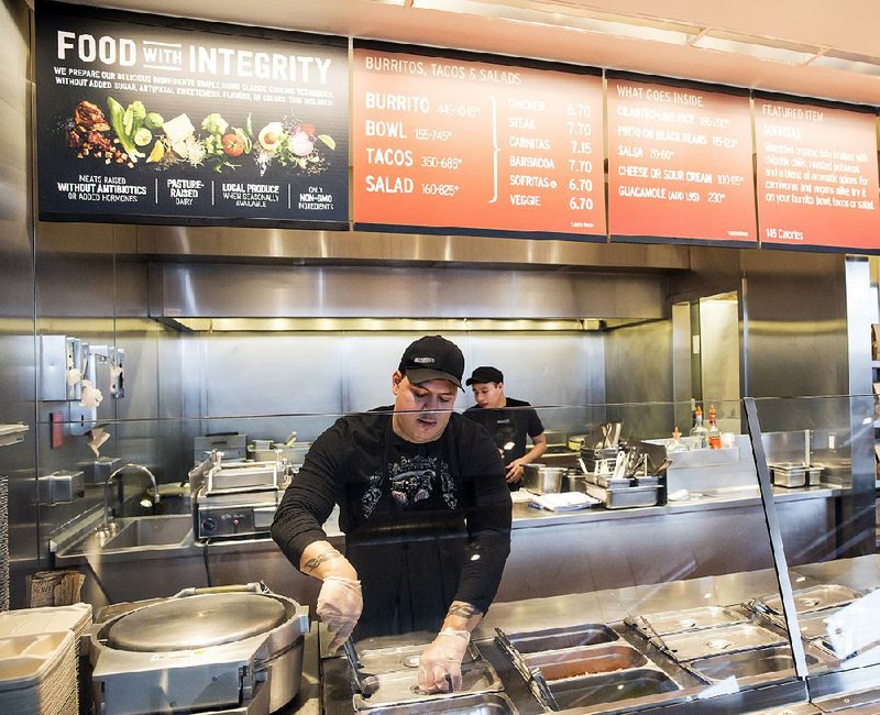 A Chipotle Mexican Grill employee prepares food at a restaurant in Seattle on Dec. 15. 
