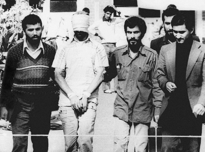 A bound and blindfolded U.S. hostage is displayed to the crowd outside the U.S. Embassy in Tehran in this Nov. 9, 1979 photo. Some of the hostages were subject to physical and psychological torture during their 444-day ordeal.