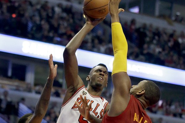 Chicago Bulls forward Bobby Portis, center, shoots against Indiana Pacers forward Paul George, left, and forward/center Lavoy Allen during the second half of an NBA basketball game Wednesday, Dec. 30, 2015, in Chicago. The Bulls won 102-100 in overtime. (AP Photo/Nam Y. Huh)