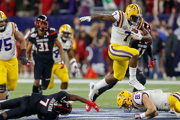 LSU running back Leonard Fournette (7) rushes past Texas Tech defensive back Jah'Shawn Johnson (7) as he hurdles tight end Colin Jeter (81) during the first half of the Texas Bowl NCAA football game Tuesday, Dec. 29, 2015, in Houston. LSU won 56-27. (AP Photo/Bob Levey)