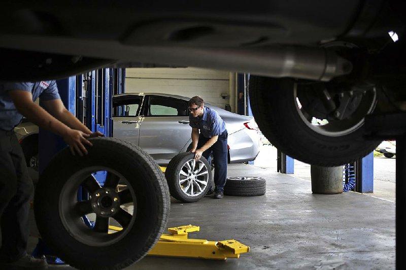 Mechanics rotate tires for customers at a Pep Boys service center in Clarksville, Ind., in June. Icahn Enterprises is buying the autoparts chain for $1 billion.