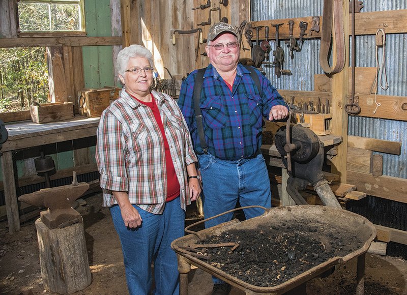 Sue Griffith and her brother, Gary Griffith, stand in the blacksmith shop on the Jackson Creek Homestead “out in the boonies” near Pearson. The two built the pioneer village as a way to honor their parents and display family antiques.