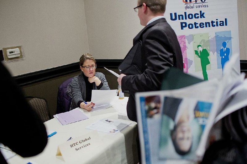 A recruiter reviews the resume of a job seeker during a job fair in Detroit on Wednesday. Unemployment claims jumped by 20,000 to 287,000, the Labor Department said Thursday. 