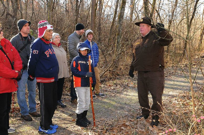 Steve Chyrchel (right), interpretive naturalist at Hobbs State Park-Conservation Area, talks about the park’s tree species during a nature hike Friday on the Sinking Stream Trail. Two guided hikes at Hobbs on New Year’s Day were part of the First Day Hikes program at several Arkansas state parks. First Day Hikes offered the opportunity to start the new year in an active and healthy way. 