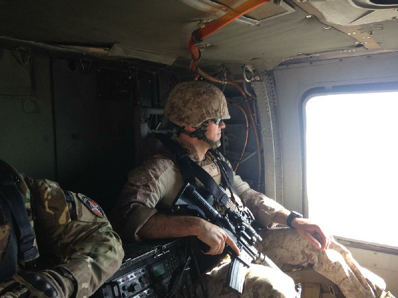 Marine Corps Capt. Austin Booth rides in a UH-60 Black Hawk helicopter on his way to training in Afghanistan.