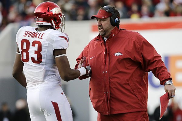 Arkansas head coach Bret Bielema congratulates tight end Jeremy Sprinkle (83) after a play against Kansas State in the first half of the Liberty Bowl NCAA college football game Saturday, Jan. 2, 2016, in Memphis, Tenn. (AP Photo/Mark Humphrey)
