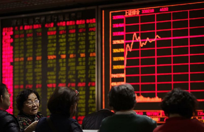 Investors chat Tuesday at a brokerage house in Beijing where they were watching stock prices. Market instability has driven away many of China’s small investors. 