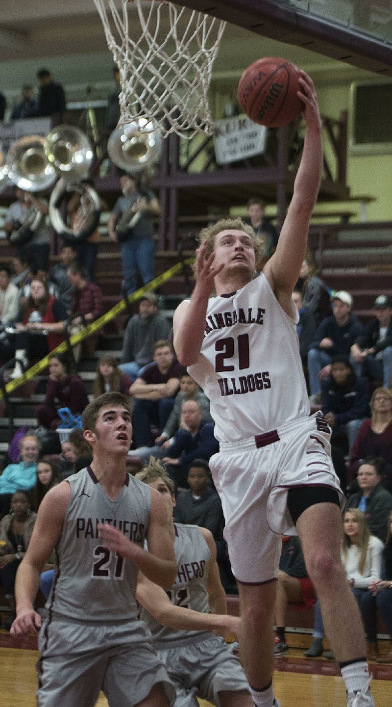 Springdale’s Kyler Mahar goes to the basket in front of Siloam Springs’ Noah Karp on Tuesday in the Bulldogs’ 67-45 victory.