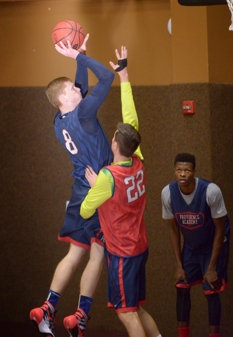 Rokas Grabliauskas (22) guards Lukas Durasas, both seniors from Lithuania, during practice Monday at Providence Academy in Rogers. 