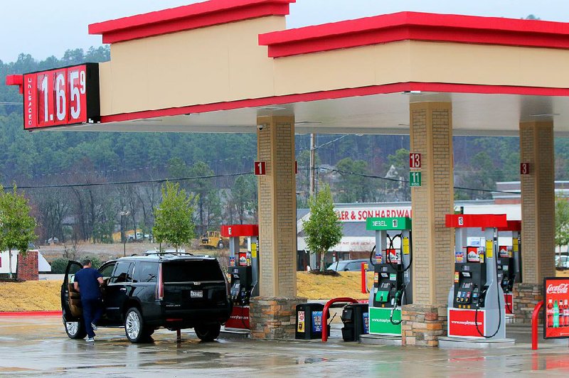 The driver of an SUV prepares to pull out after filling up at a Murphy Express station Thursday in Little Rock. As oil prices have dropped, so has the cost of gasoline. Arkansas’ average price Thursday was $1.75 a gallon. 