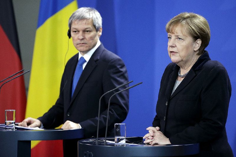 German Chancellor Angela Merkel and Romanian Prime Minister Dacian Ciolos talk to journalists Thursday in Berlin, where Merkel called for her European allies to share more responsibility on the migrant crisis. 