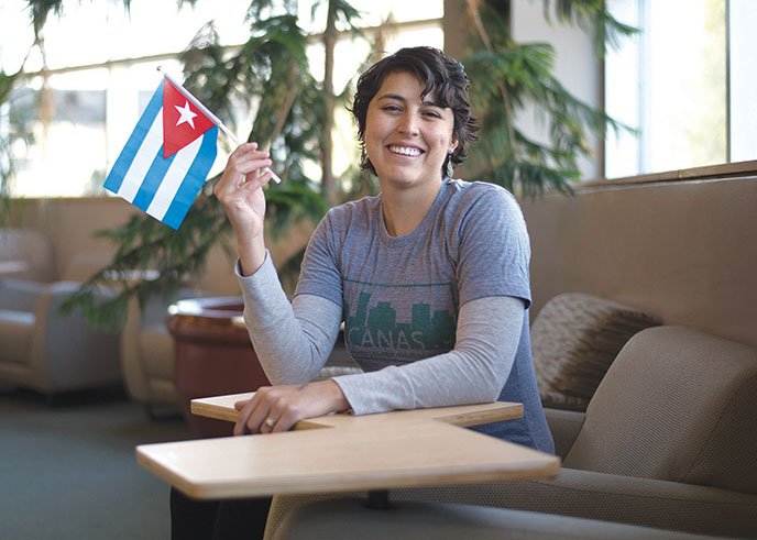 Sandra Leyva holds a Cuban flag as she sits in the Faulkner County Library in Conway. She spent eight days in Cuba in November, touring farms and attending the fifth annual AgroEcology Conference. Leyva is founder of The Locals, a nonprofit organization whose mission includes promoting the local-food movement and teaching people to grow food sustainably.