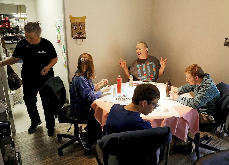 Brushes store manager Sharla Eudy (left), Brooke Williams (seated, clockwise from left), B.J. Standley, Bryon Speas and Tyler Piepergerdes decorate bottles. 