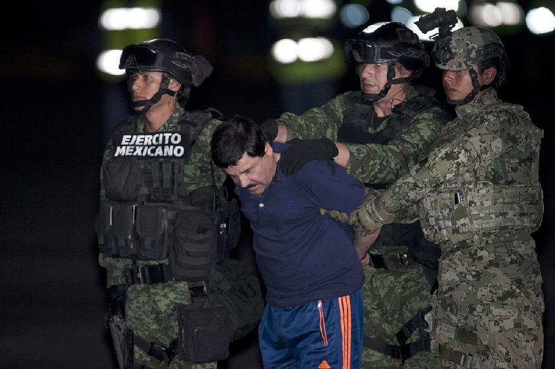 Mexican soldiers escort a handcuffed Joaquin “El Chapo” Guzman to a helicopter Friday in Mexico City, and he was flown to the same prison he escaped from in July.