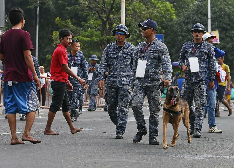 Members of the Philippine coast guard and their dogs patrol Saturday in Manila during the annual procession of the Black Nazarene. Security was particularly heavy at this year’s celebration.