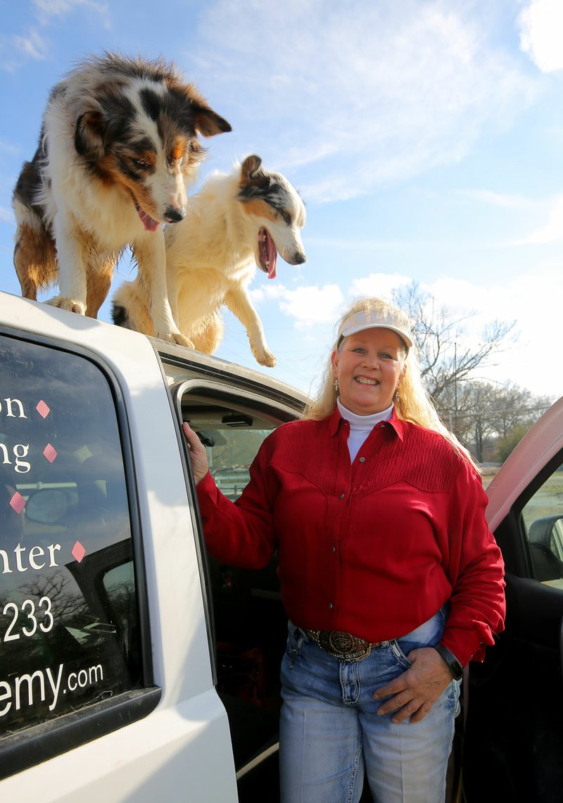 Toby Hart stands with her dogs Friday afternoon at her Conway farm.