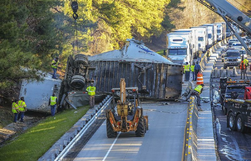 Emergency crews work Tuesday morning to separate two truck trailers from the westbound lane of Interstate 30 southwest of Benton in Saline County. The westbound lane in a construction zone was closed for nearly 12 hours. 